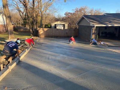 Concrete driveway installation underway in Oklahoma City, showcasing workers and equipment on-site.