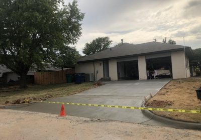 A house with a driveway and a garage prominently featured in the front yard.