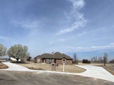 A house with a driveway and a grassy area in front, showcasing a well-maintained exterior.